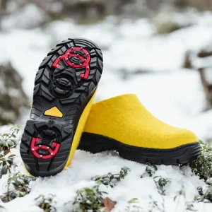 Yellow Lahtiset Spike! shoes on an icy lingonberry mound