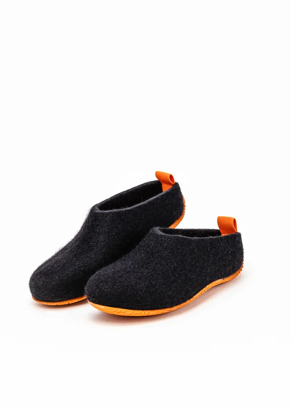 Black wool-felt shoes with an orange heel loop and matching sole, on a studio background.